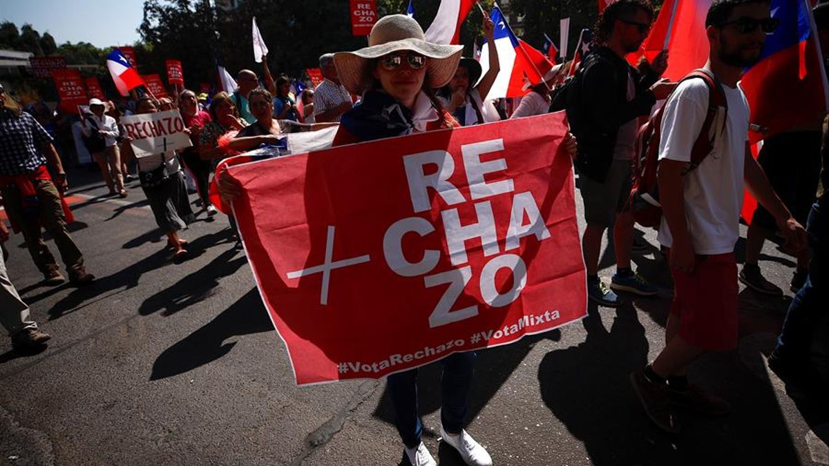 Una mujer con un cartel de rechazo a la nueva Constitución en las protestas del 15 de febrero de 2020