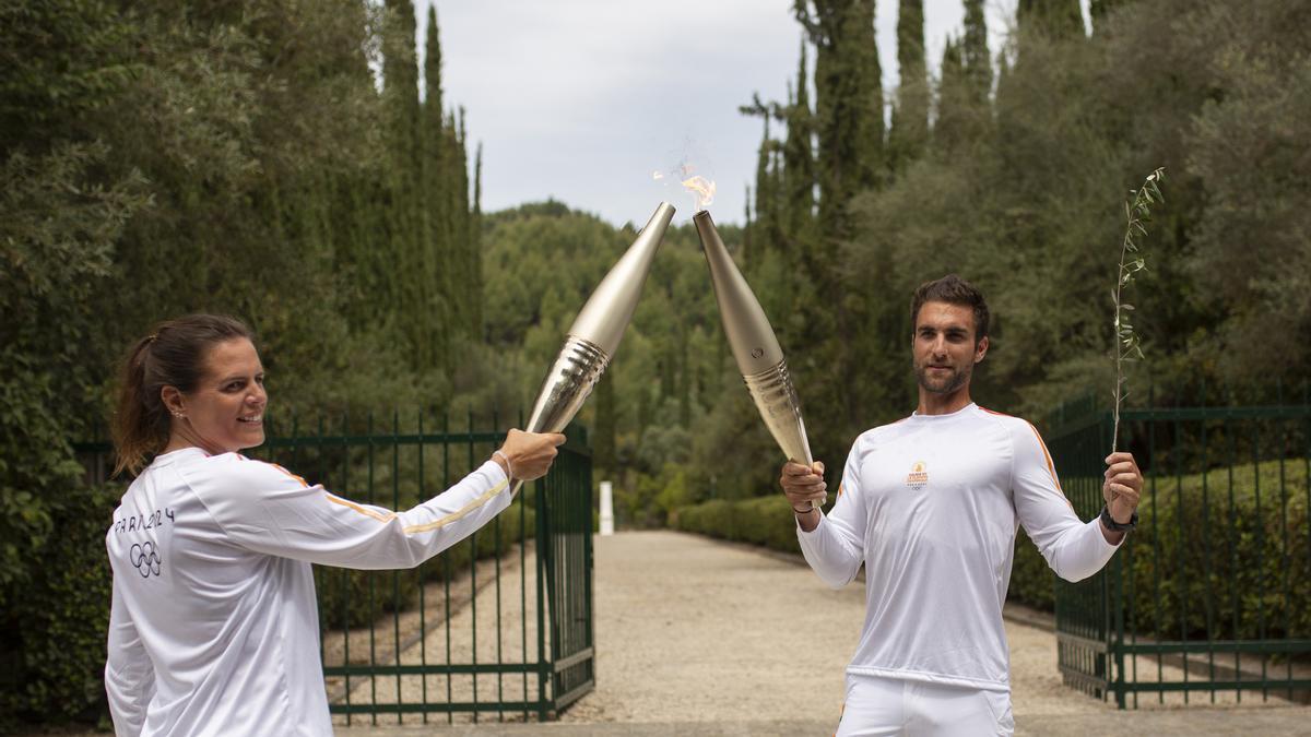 16 de abril de 2024, Grecia, Olimpia. Stefanos Ntouskos enciende la antorcha sostenida por la nadadora francesa Laure Manaudou