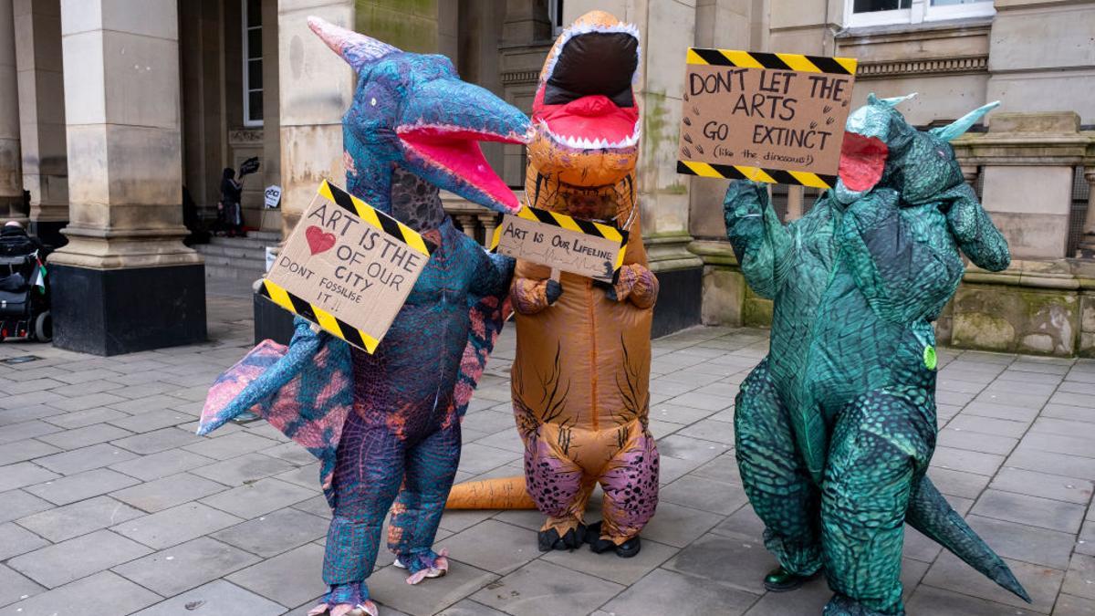 Un grupo de personas, disfrazadas de dinosaurios, durante una protesta contra los recortes de ayudas públicas a la cultura en Birmingham, el 2 de marzo.