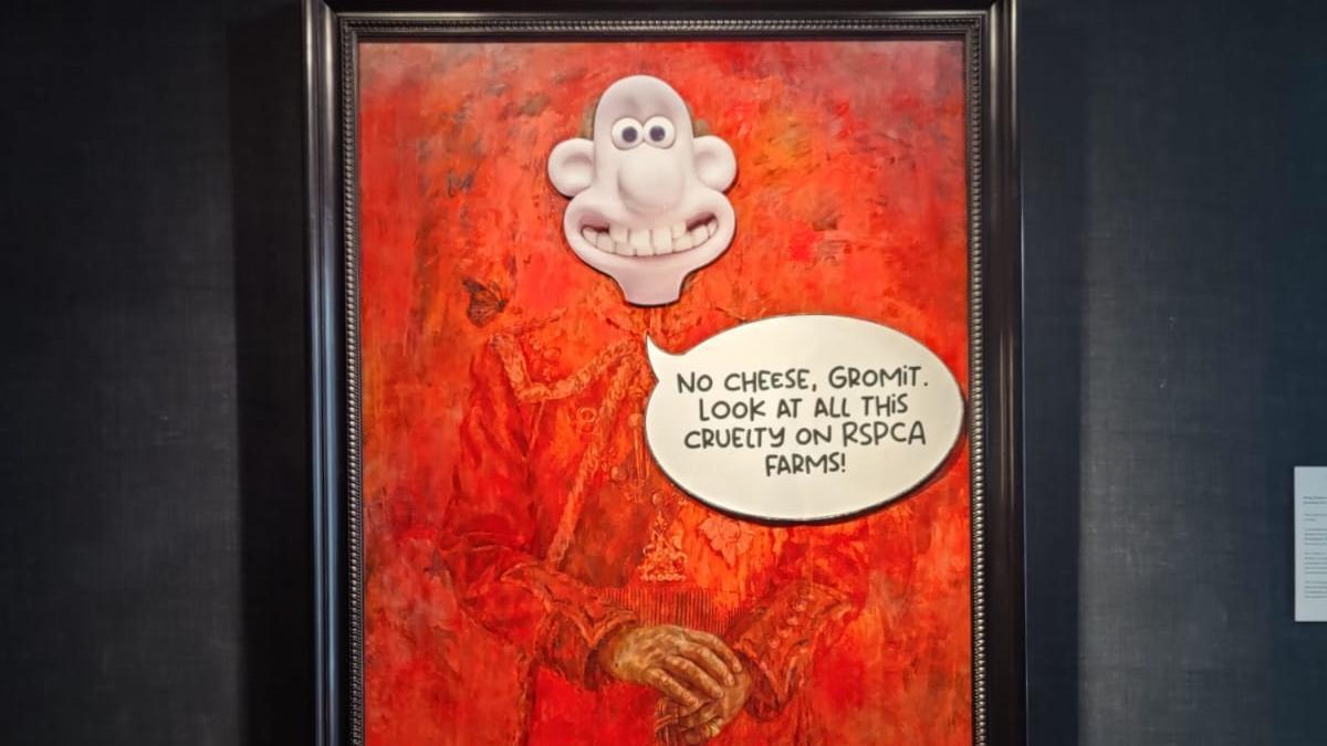 Activistas animalistas cubren el retrato rojo del rey Carlos de Inglaterra con la cara de Wallace