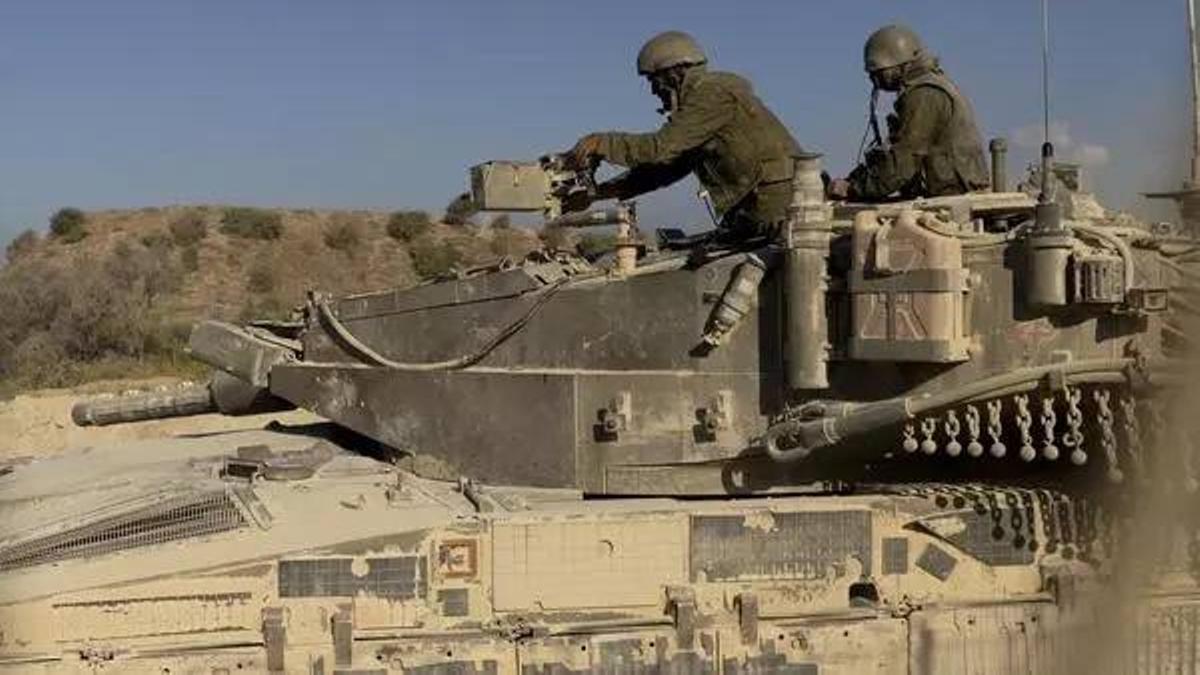 Soldados israelíes en un tanque, a punto de entrar en Gaza