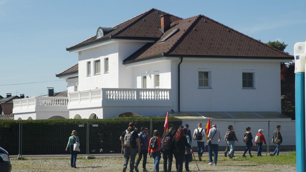 Familiares de deportados españoles pasando por delante de la antigua puerta de entrada Gusen, reconvertida en un chalet de lujo